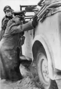 Jenderal Erwin Rommel membantu mendorong mobilnya yang terjebak pasir 